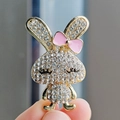 Lindo broche de conejo en metal dorado con diamantes de imitación y lazo rosa - Conejo con Lazo de Strass