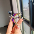 Close-up of blue swallow brooch featuring colorful enamel wings and sparkling rhinestones - Purple