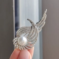 Elegant silver angel wing brooch with sparkling crystals and a lustrous pearl in hand - White Pearl Style (XZ0346-1)