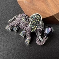 Macro detail of elephant brooch featuring purple rhinestones and vintage silver finish - Pink