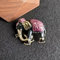 Dettaglio macro della spilla elefante in smalto con accenti dorati e motivi rosa - Viola