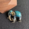 Dettaglio macro di spilla a elefante con mantello in smalto verde e bordi dorati - Blu
