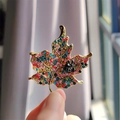 Macro shot of maple leaf brooch with colorful crystals and black flower detail - Colorful Maple Leaf Style (XZ0486-1)