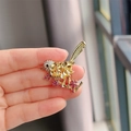 Close-up of bird brooch with yellow crystals and purple flowers on golden branch - Bird and Plum Style (XZ0517-1)
