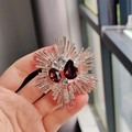 Detail of vintage sunburst brooch featuring purple crystals and gold plated rays - Fuschia