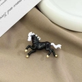 Elegant running horse brooch in black and white enamel with gold accents on fabric - Vintage Horse Brooch Black