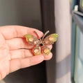Elegante gouden vlinderbroche met oranje kattenoogstenen en gele strassteentjes - Geel