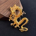 Golden dragon brooch pin with intricate scale details on elegant gray fabric backdrop - Yellow