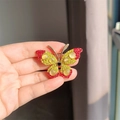 Glinsterende vlinderbroche met rode en gele strass steentjes in goudkleur - Rood