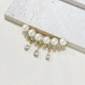 Elegante spilla di perle con ciondoli a nappa per maglioni e completi su sfondo di pietra - Stile con Nappina di Perle