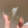 Golden Pegasus brooch with white zircons held by hand showing delicate jewelry scale - Hollow Pegasus Brooch
