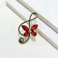 Detailansicht der Musiknoten Brosche mit roten Schmetterling Kristallen auf Stoff - Roter Schmetterling Strass Note Brosche