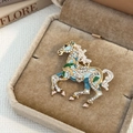Detailed close-up of a jumping horse brooch with crystals and colorful enamel finish - Blue