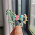 Spilla a cavallo di giostra in smalto verde con dettagli sella rosa finitura oro - Unicorno Verde (XZ0289-3)