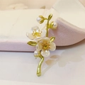 Detailansicht der Jasmin-Brosche mit Perlen und grünen Blättern auf einer Schmuckschatulle - Jasminblüten-Stil