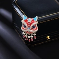 Traditionelle rote Emaille-Löwenbrosche mit funkelnden Kristallen auf schwarzem Leder - Chinesischer Löwentanz