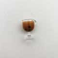 Macro view of miniature bubble tea cup model with realistic brown liquid and black pearls - Dark Coffee