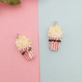 Détail de breloques popcorn en résine avec boîtes rayées rouges et boucles argentées - Pop-corn