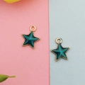 Detailed view of star-shaped alloy pendants with dark green enamel and gold-plated edges - Green Celestial Star
