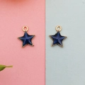 Detailed view of dark blue enamel star charms with gold beaded edges and hanging loops - Blue Celestial Star