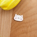 Detail of cute white enamel cat pendant for DIY jewelry on light wood background - White Cat Head