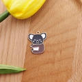 Detailansicht eines süßen Emaille-Koala-Anhängers für DIY-Schmuck auf Holzuntergrund - Koala