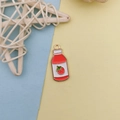 Macro detail of red strawberry drink alloy pendant with gold-plated ring on bicolor background - Strawberry Juice