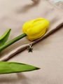 Close-up of gold star charms on silk with a yellow tulip for jewelry making - Pentagram