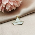 Detailed close-up of a white enamel paper boat charm with SS Georgia text on gold metal - Paper Boat