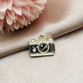 Detail of vintage camera alloy pendant in white and black enamel with gold metallic finish - Camera