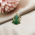 Detail of green enamel frog pendant with gold metal edges on champagne satin fabric - Frog Toy