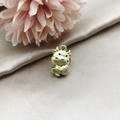 Macro shot of a golden ox charm holding a Fu bag on luxury silk and floral background - Matt Gold Red Fortune Ox