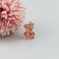 Detail van roze berenhanger van hars met glitters en zilveren oogje voor DIY-sieraden - Rood