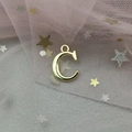 Detailed macro view of a golden alloy letter C pendant with star sequin background - Letter C