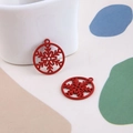 Vue macro d'un pendentif flocon de neige rouge mat pour bijoux DIY et accessoires Noël - Flocon de neige rouge