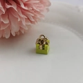 Macro detail of green Christmas gift box charm with gold bow for jewelry making - Yellow