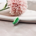 Vue détaillée d'un petit pendentif fer à repasser en résine sur tissu de soie doux - Fer à repasser électrique
