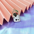 Detail of enamel black cat charm inside a 2 of clubs card bag with green bow for DIY crafts - Black Playing Card Cat