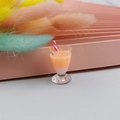 Macro shot of miniature bubble tea resin charm in cocktail glass with striped straw - Orange Pink Gradient Style (1)