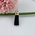 Detail of a black faux suede tassel pendant with a metallic golden cap for DIY accessories - Black