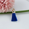 Close-up of a dark blue faux suede tassel pendant with a golden metal cap and ring - Dark Blue