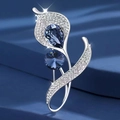 Elegant silver calla lily brooch with white crystals and deep blue gemstones on fabric - White Molan Flower
