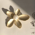 Detail der mattgoldenen Blütenbrosche mit gebürsteter Metallstruktur und weißer Perle - Mattgold Weiße Perle