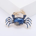 Dettaglio macro della spilla a granchio con smalto blu scuro e motivi corallo dorati - Blu