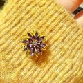 Detailaufnahme einer lila Marquise-Brosche auf einem gelben Strickstoffhintergrund - Blume Strass (Gold Lila) / Gold Lila
