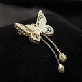Dettaglio macro di spilla a farfalla dorata con ali traforate, strass e nappe lunghe - Spilla Farfalla Svuotata-Oro