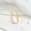 Dettaglio di una spilla a forma di gatto in smalto bianco con finiture in oro elegante - Stile Gatto Bianco