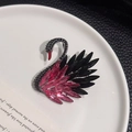 Exquisito broche de cisne de cristal con degradado negro y rosa en un plato blanco - Cisne Negro