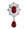 Dettaglio di spilla vintage in argento con rubino centrale e ciondolo di cristallo - Rosso