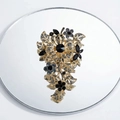 Macro detail of luxury floral brooch with black gemstones and crystals on golden alloy - Gray